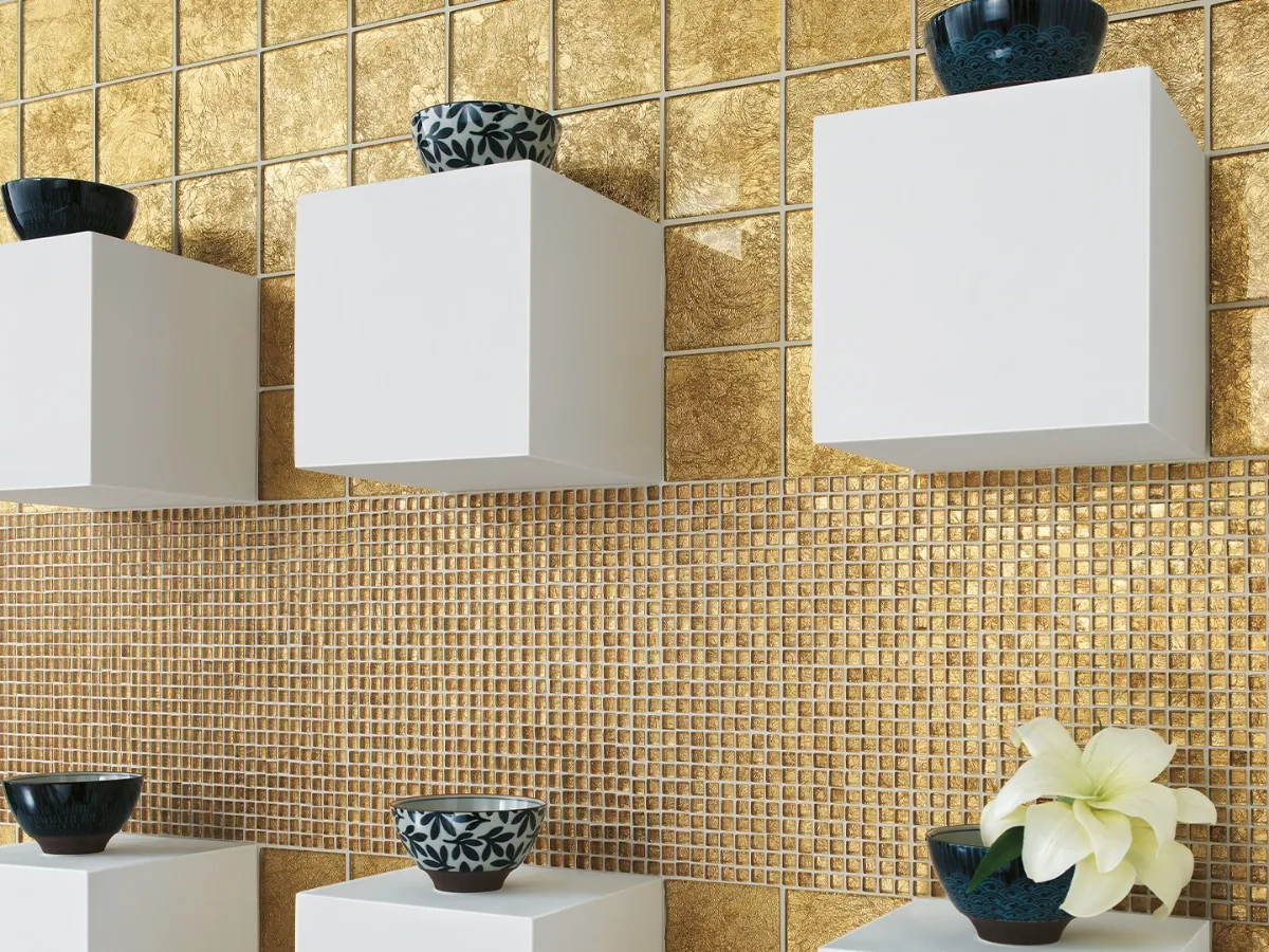 Parete con mosaico vetroso oro e mensole cubiche bianche